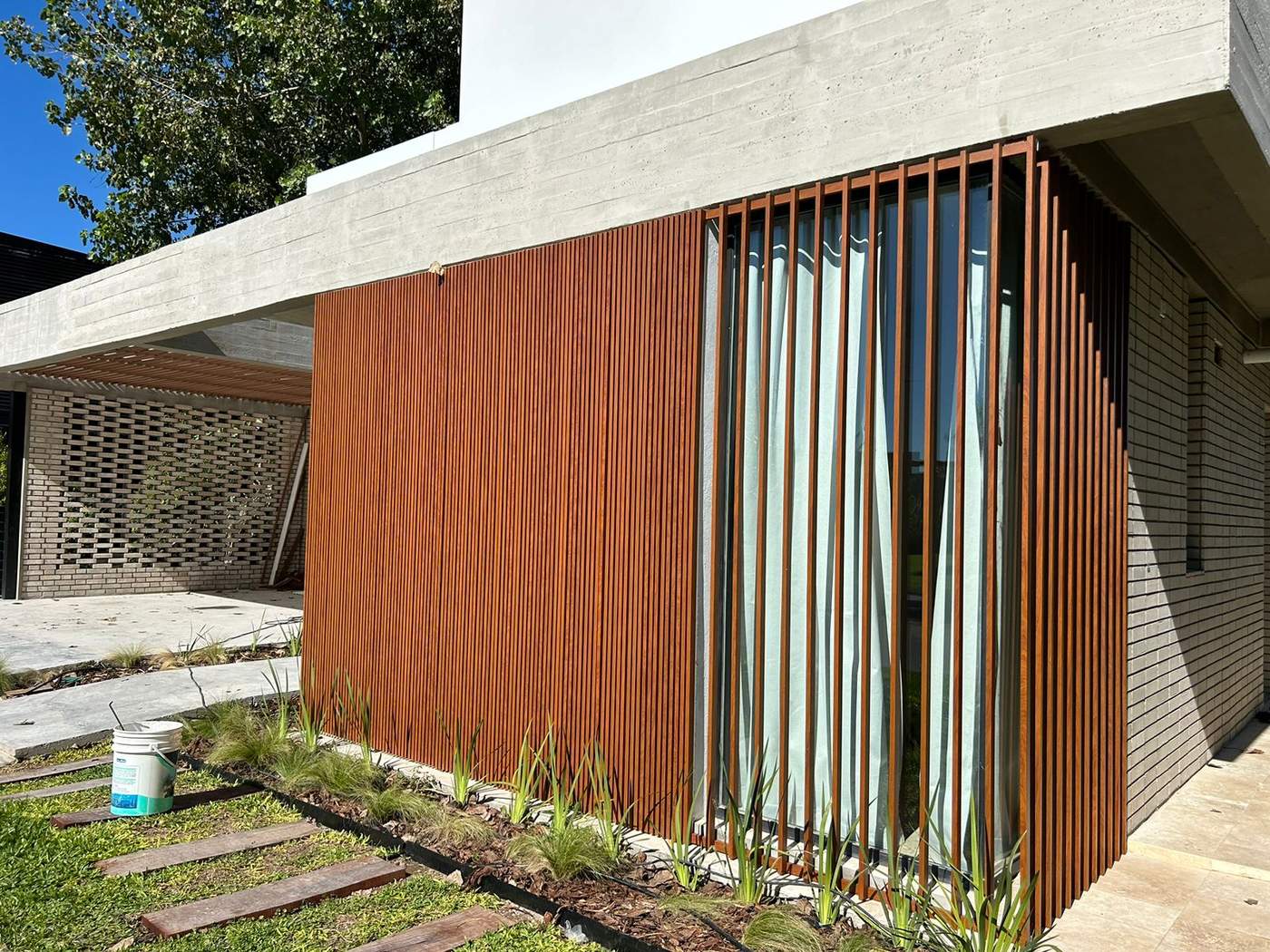 Fachada casa SAMAC con parasoles de madera